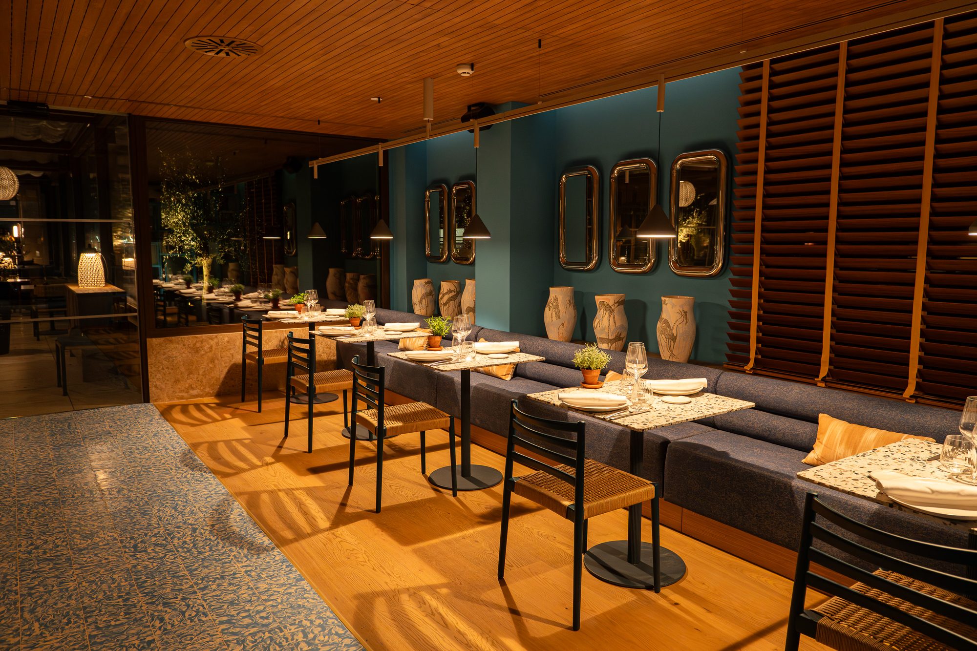 Sala del restaurante Cañitas Málaga en ME Málaga by Meliá, con bancos corridos y paredes azules