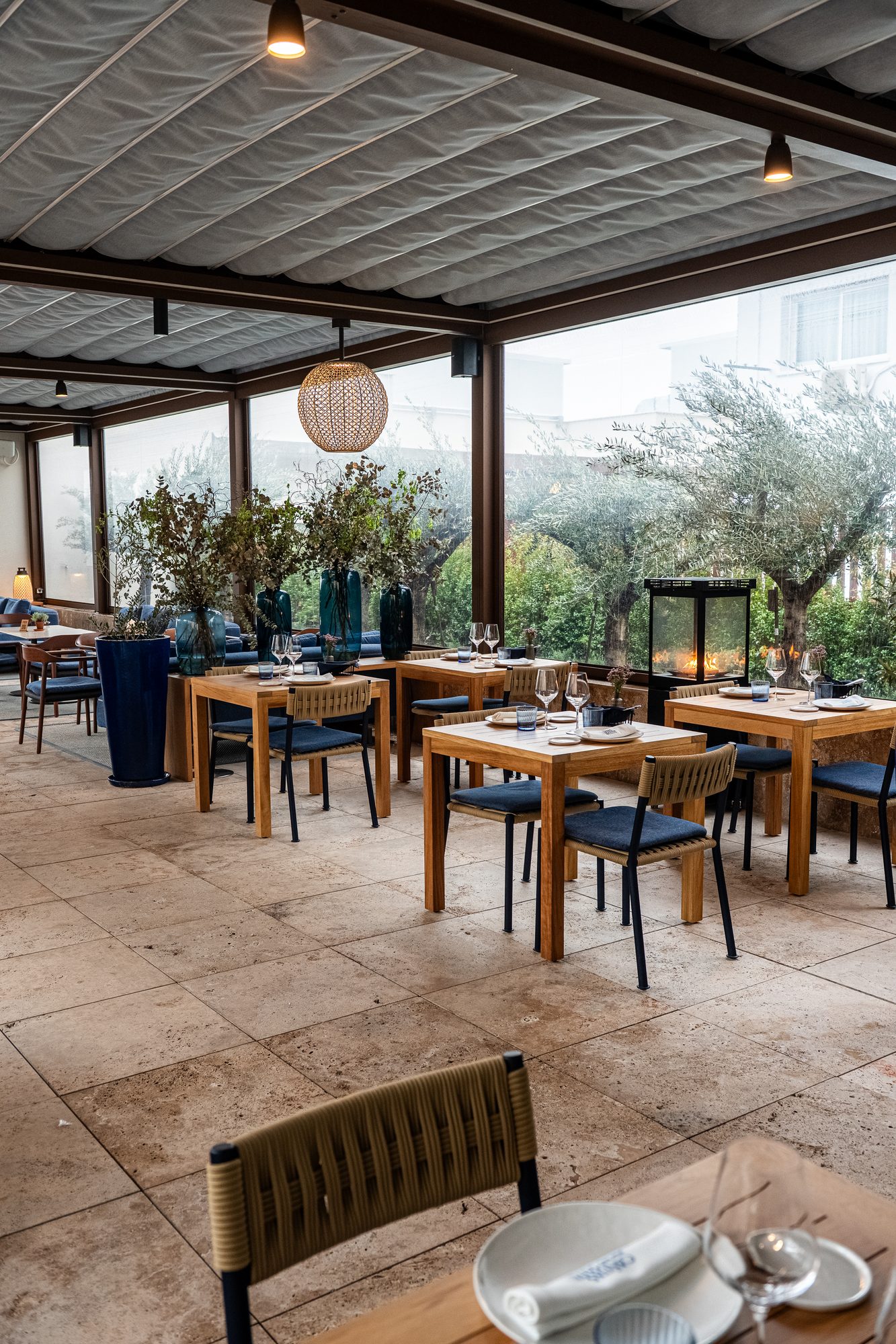 Mesas de la terraza de Cañitas Málaga con vegetación y luz natural